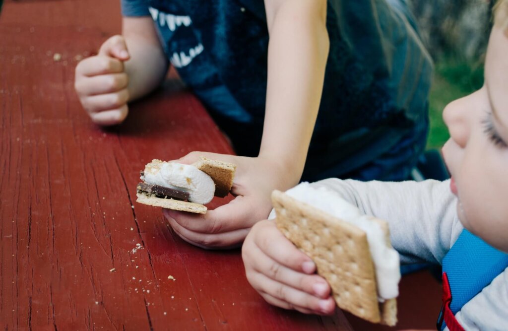 family-friendly RV park with family activities two kids enjoying s'mores pictured